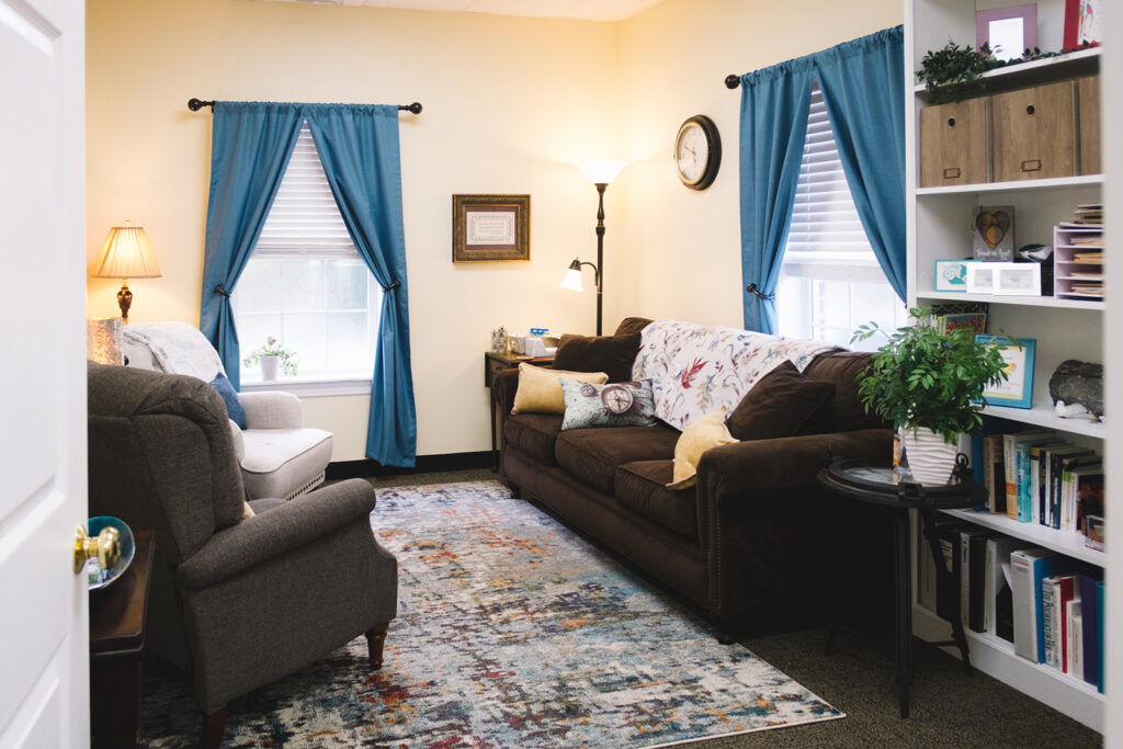 The gallery starts with a picture of the front of the building. The building is red brick with white pillars. The next pictures show the suite lobby, the hallway, and then Dr. Perkins' office seating, bookshelves, and decor details. 